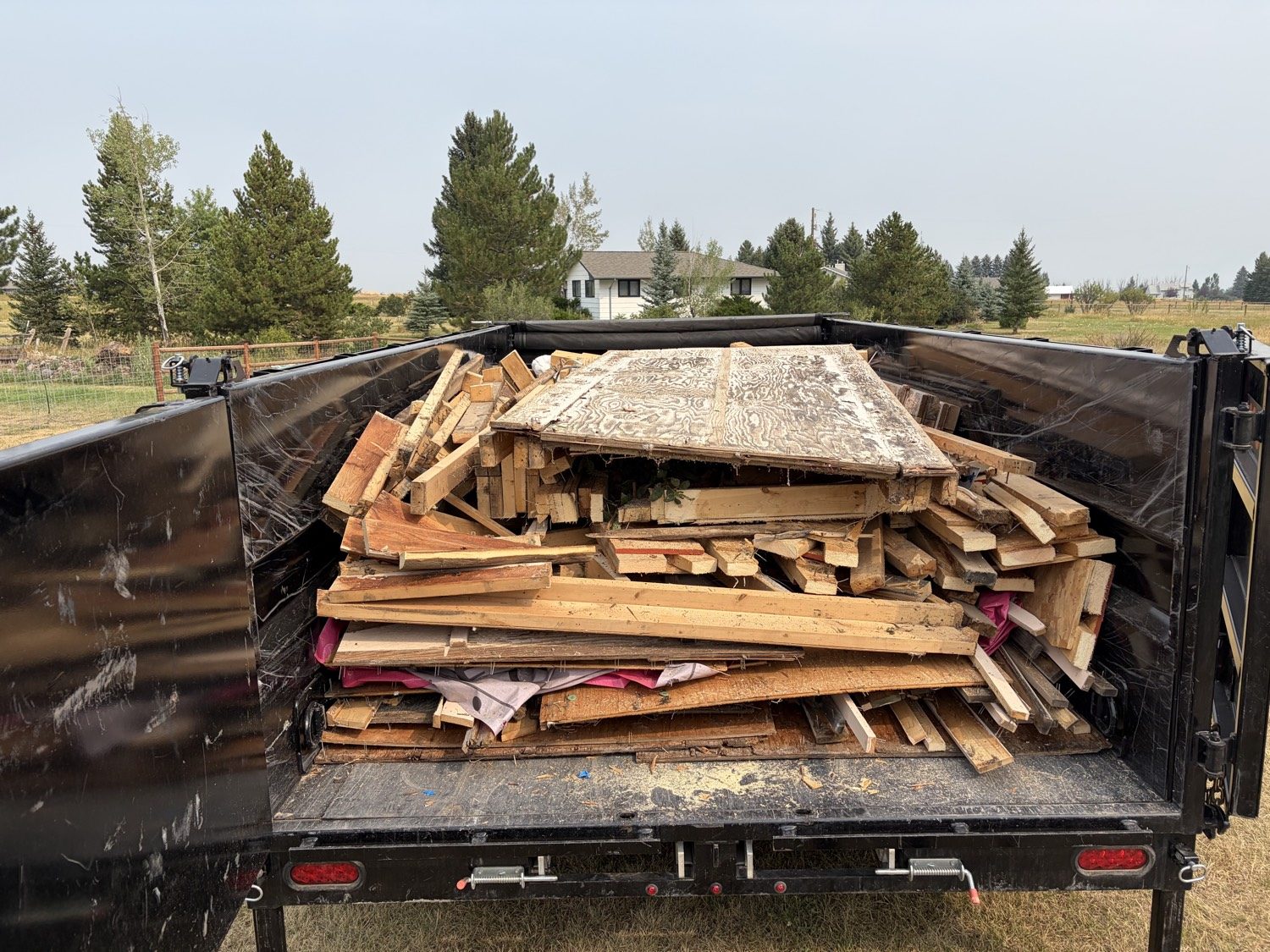 Dump trailer loaded with scrap lumber and plywood